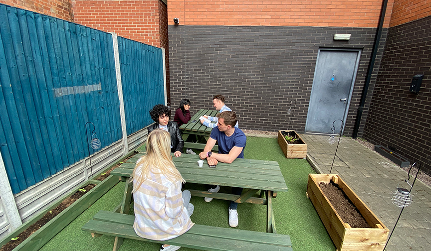 Loughborough students gathering in the Block garden chatting